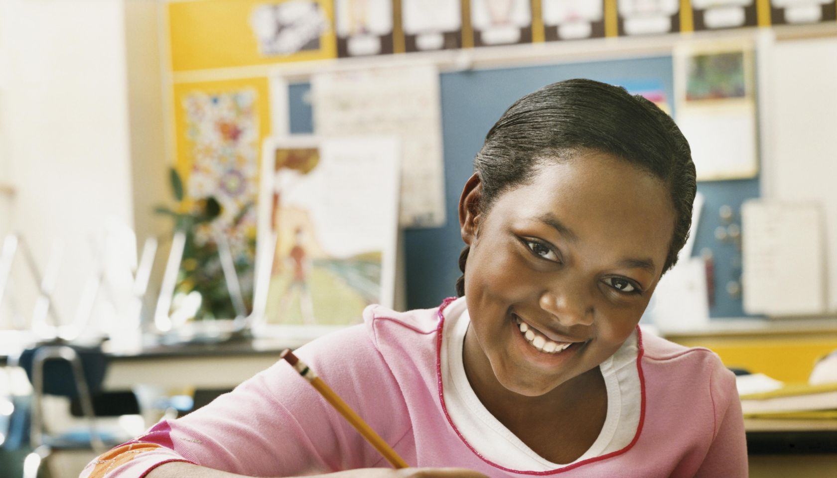 Portrait of a Schoolgirl Writing in Her Exercise Book in a Classroom