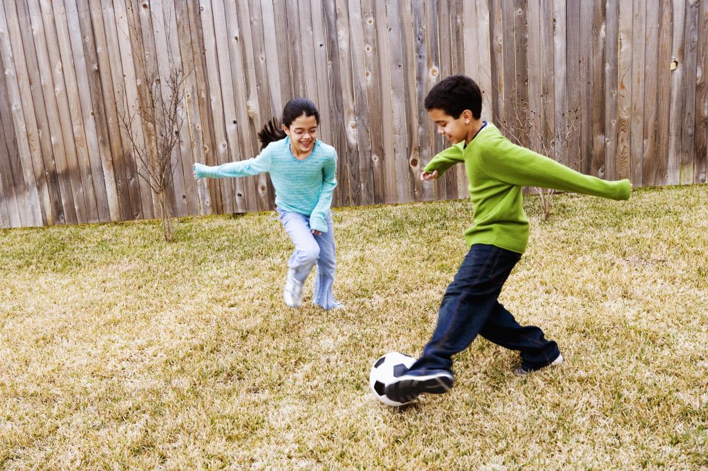 Children ( 8-11) playing football in ground