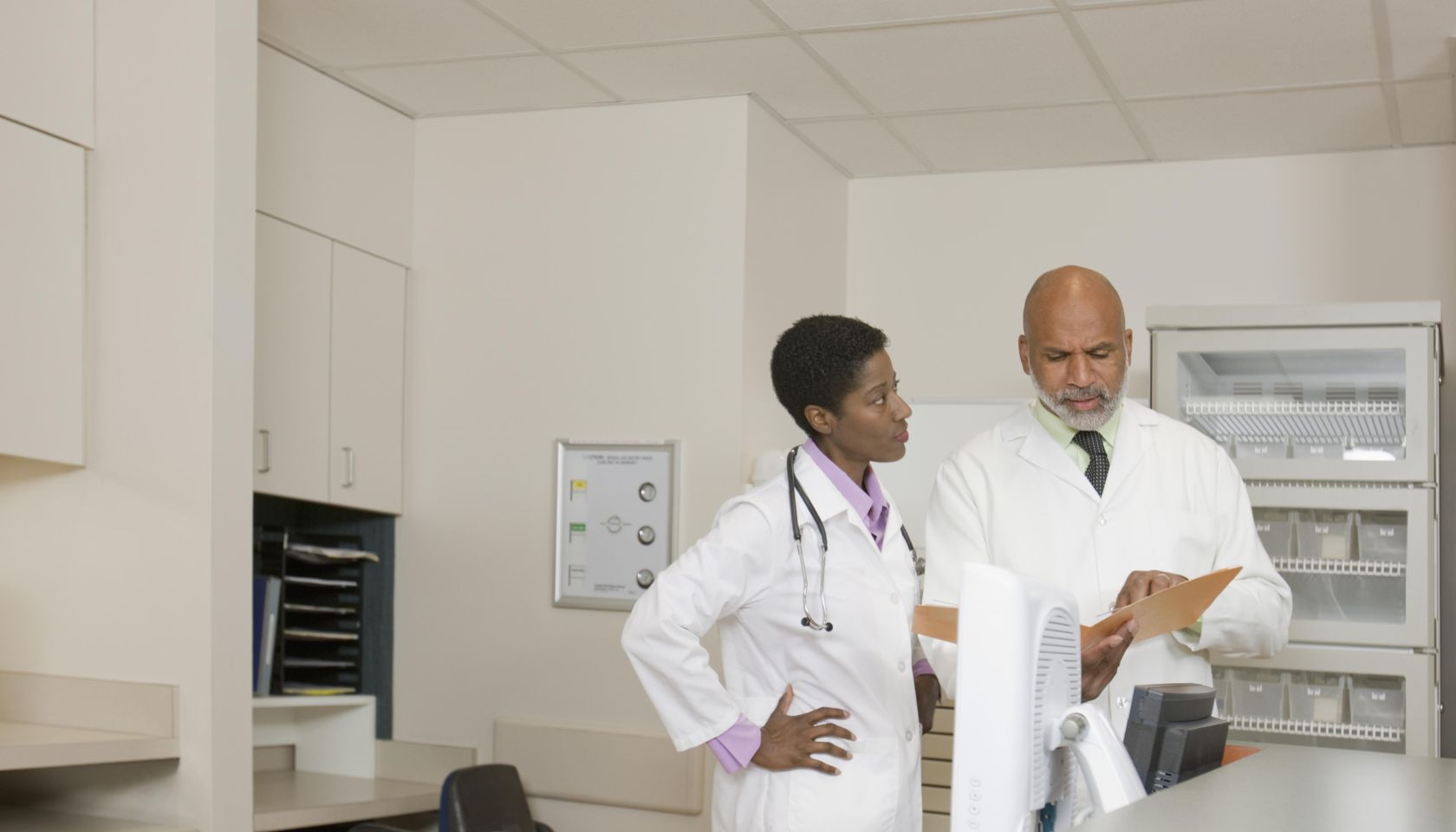 Doctors reviewing file in hospital