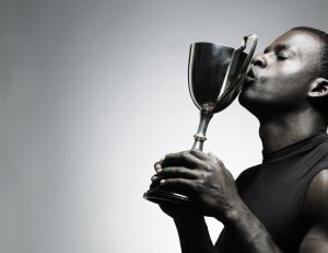 Young man kissing trophy, close-up