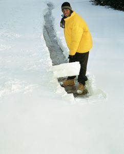 Teenage boy (16-18) shoveling path through snow, elevated view