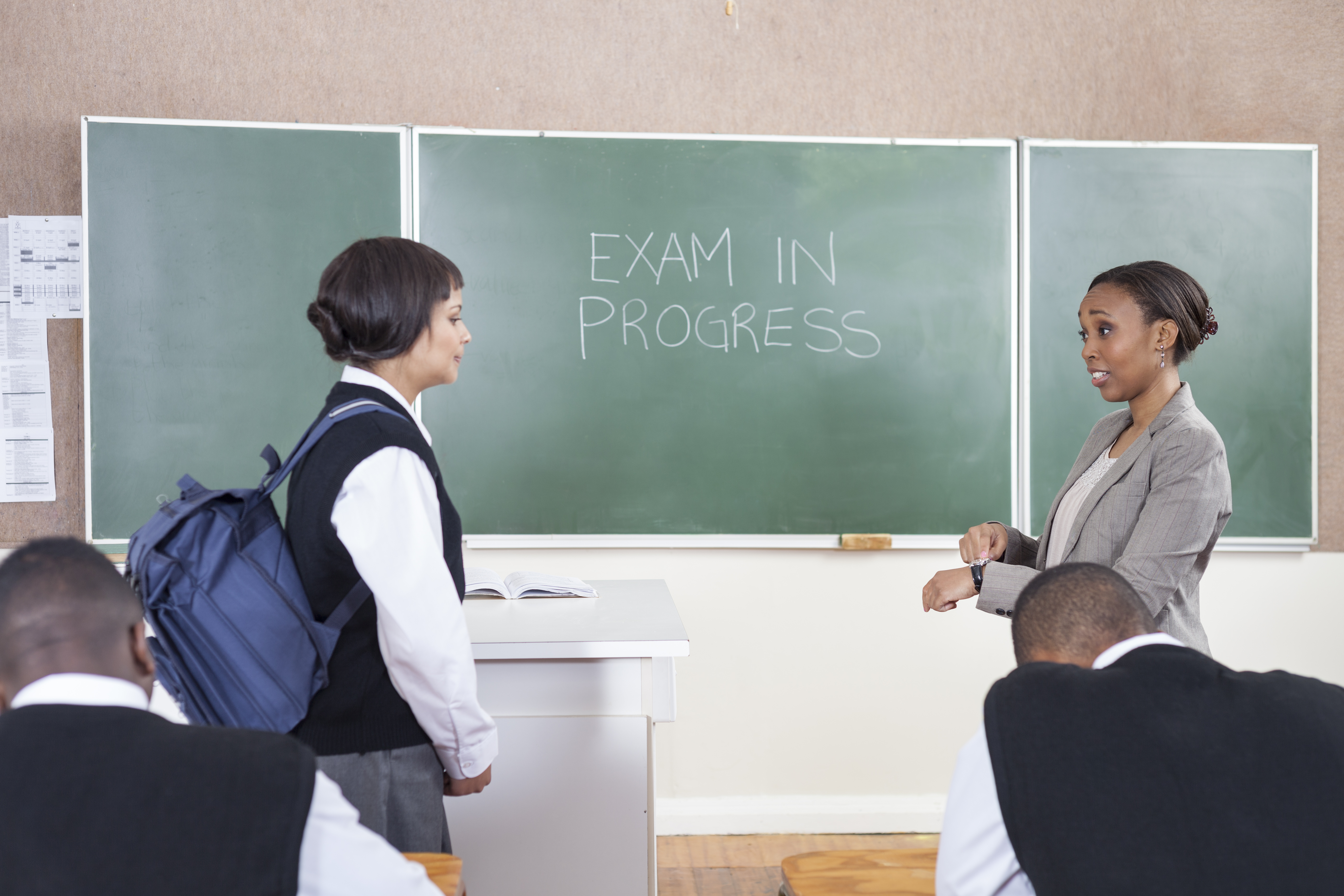 A teacher scolding a student for late arrival for the exam A