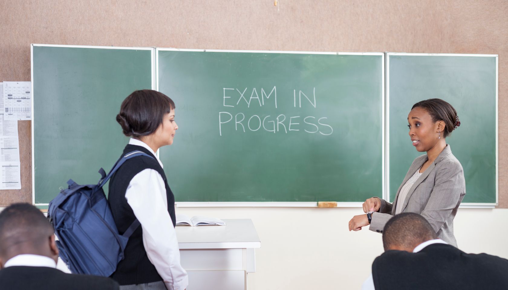 A teacher scolding a student for late arrival for the exam A