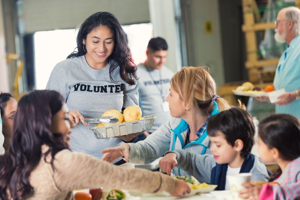 Volunteer serving healthy meal to families in food bank