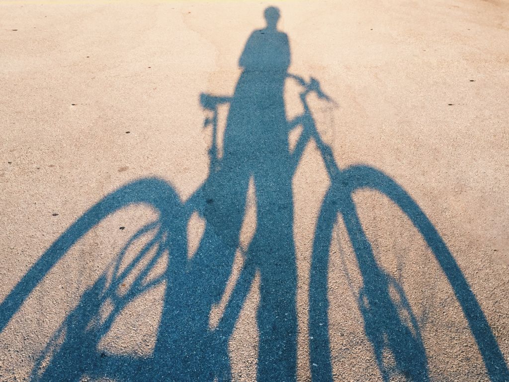 Shadow Of Man With Bicycle On Road During Sunny Day