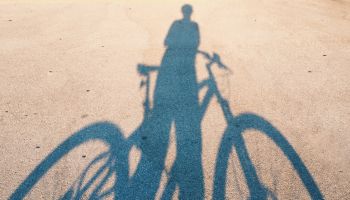 Shadow Of Man With Bicycle On Road During Sunny Day