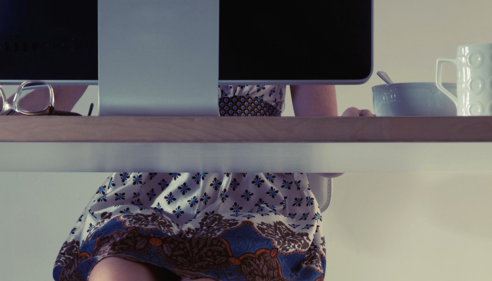 woman's feet in slippers & her cat beneath a desk