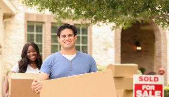 Excited young couple moves boxes into their new home.
