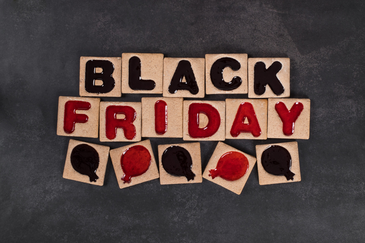 Black friday Square cookies in black and red marmalade filling in the shape of the words Black Friday and balloons. Dark background. Top view