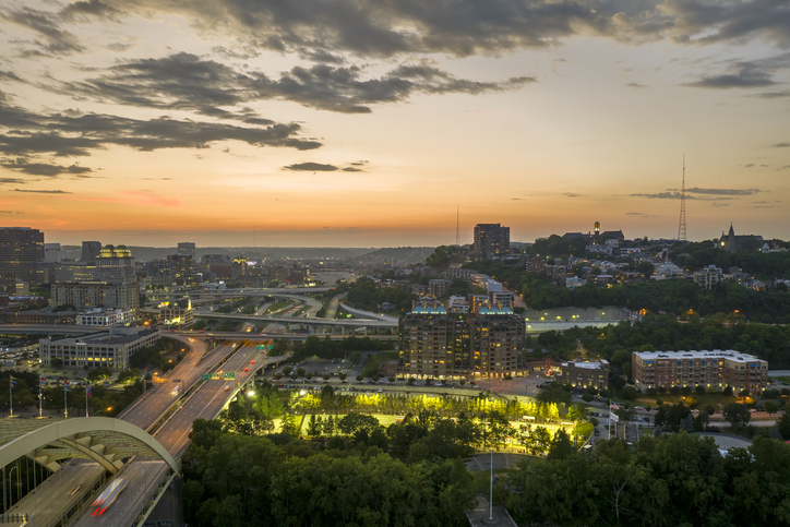 Aerial view of American freeway intersection at night with fast driving cars in Cincinnati, Ohio. View from above of USA transportation infrastructure