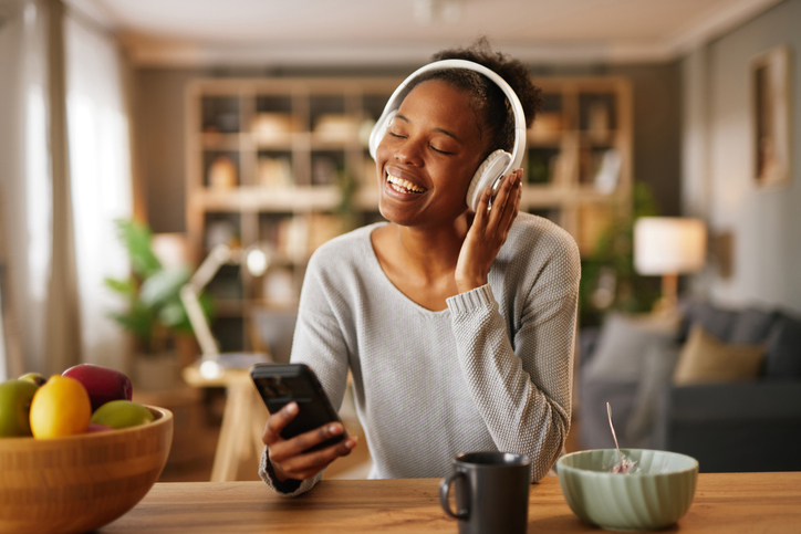 Young adult woman enjoying music, relaxing at home