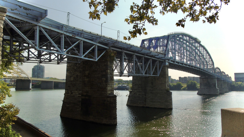 looking up at the purple people bridge (newport southbank bridge), a truss bridge spanning the ohio river in cincinnati.