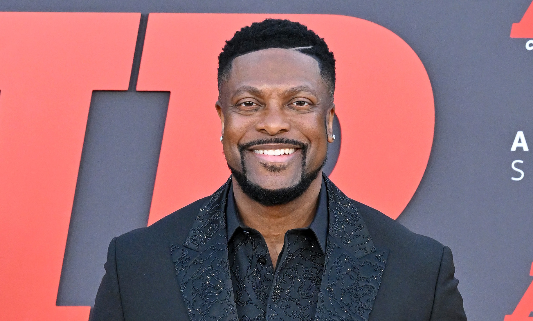 A smiling Black man wearing a black suit and shirt attends the Amazon Studios' world premiere of "AIR" at Regency Village Theatre in Los Angeles.