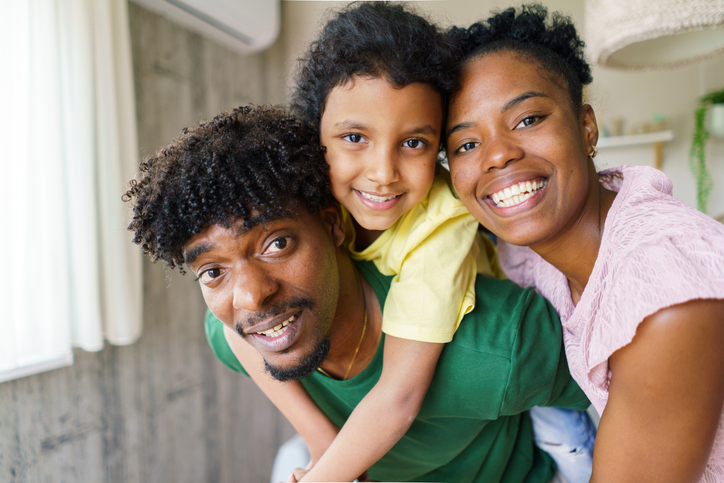 Happy african family enjoying piggyback ride at home